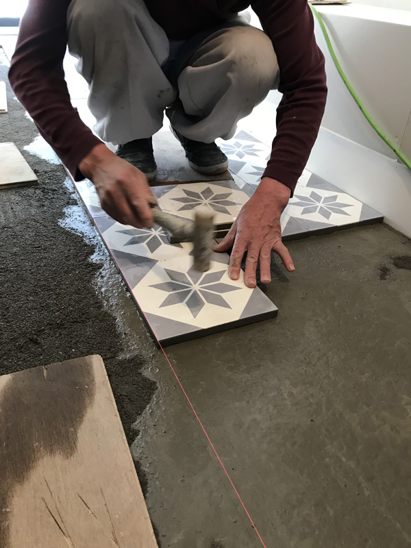 直線、平行をガイドで出しながらタイルを並べ、軟らかなハンマーで叩いていきます carreau cimentのエトワール柄の床がフレンチなカフェ,施工例,店舗プランニング,アンティークタイル,モルタル床,5